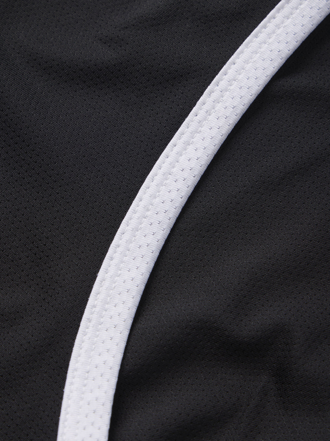 Detailed texture of PB5star's women's Core Tank in black with a contrasting white trim, showcasing the high-quality, breathable mesh fabric designed for pickleball players seeking comfort and style.