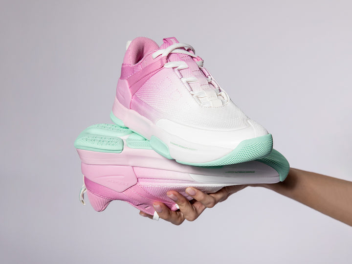Women's Court 2 pickleball shoes in pink with mint green gum outsole held in hand against light background
