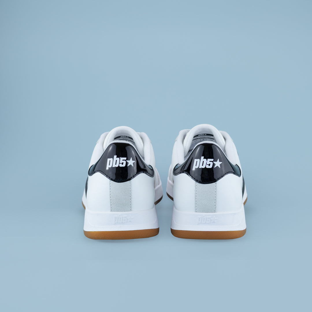 Rear view of PB5STAR Cosmic white and black sneakers with gum soles and pb5 logo on heel, displayed on light blue background.