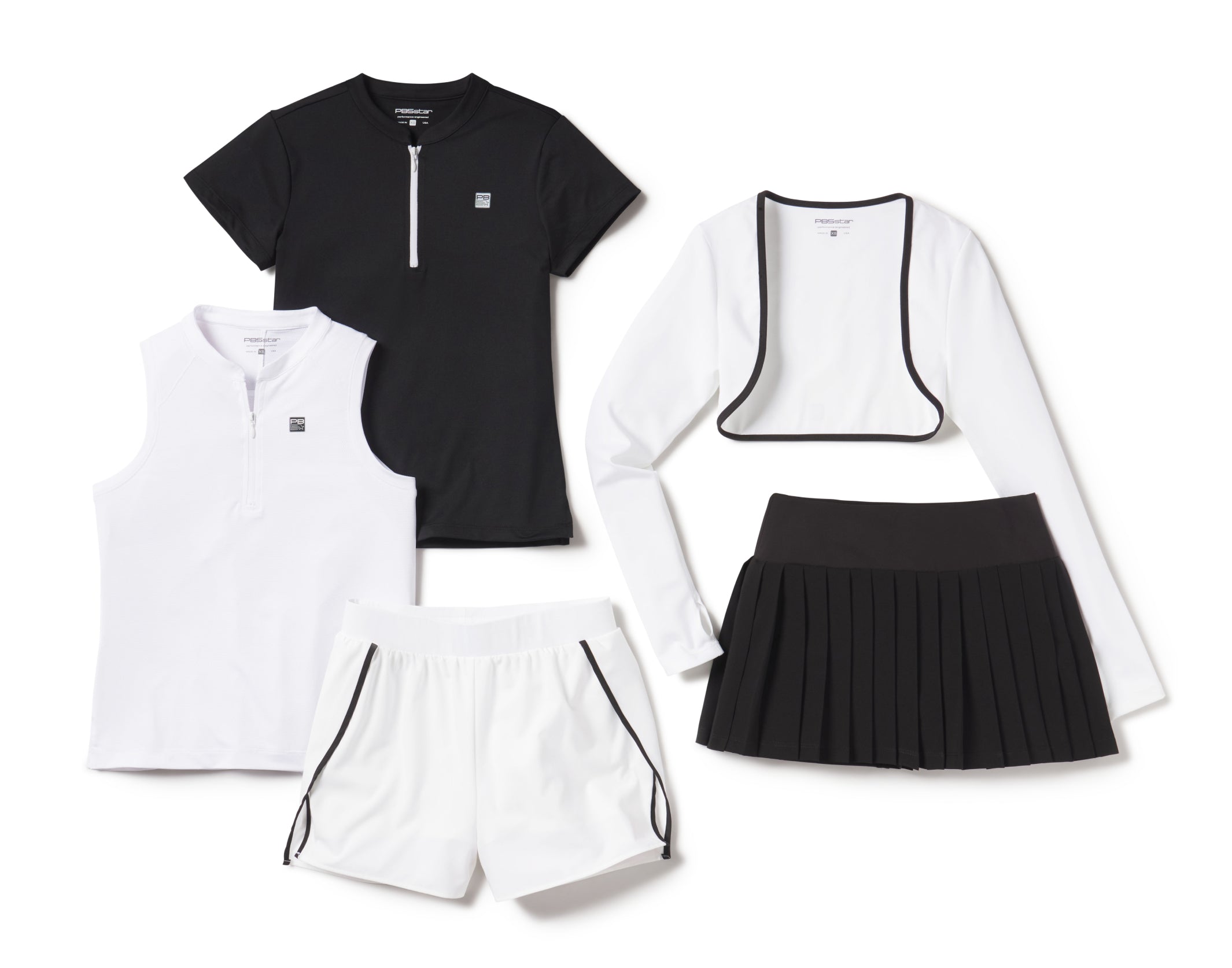 Flat lay of PB5star black and white pickleball apparel including shirts, shrug, shorts, and pleated skirt on white background