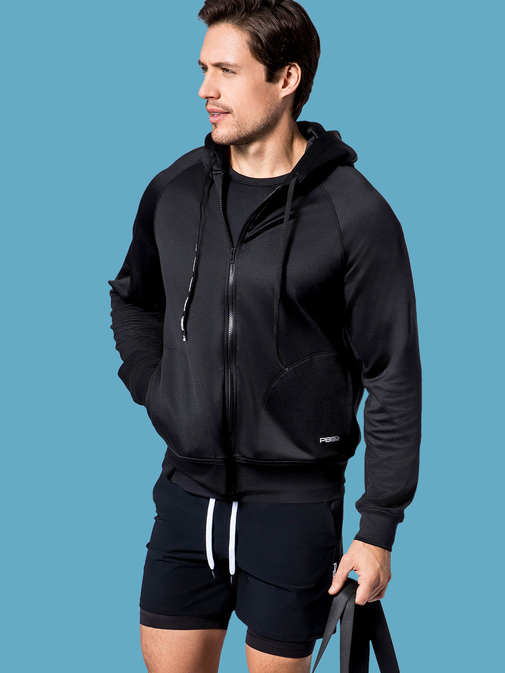 Man modeling a PB5 Star black performance full-zip hoodie with brand logo.