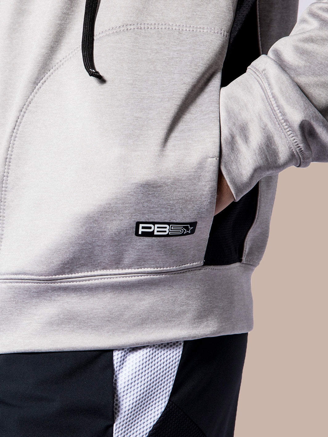 Close-up of the PB5star logo on a grey heather Performance Full Zip Hoodie with black trim, highlighting the quality fabric and design.