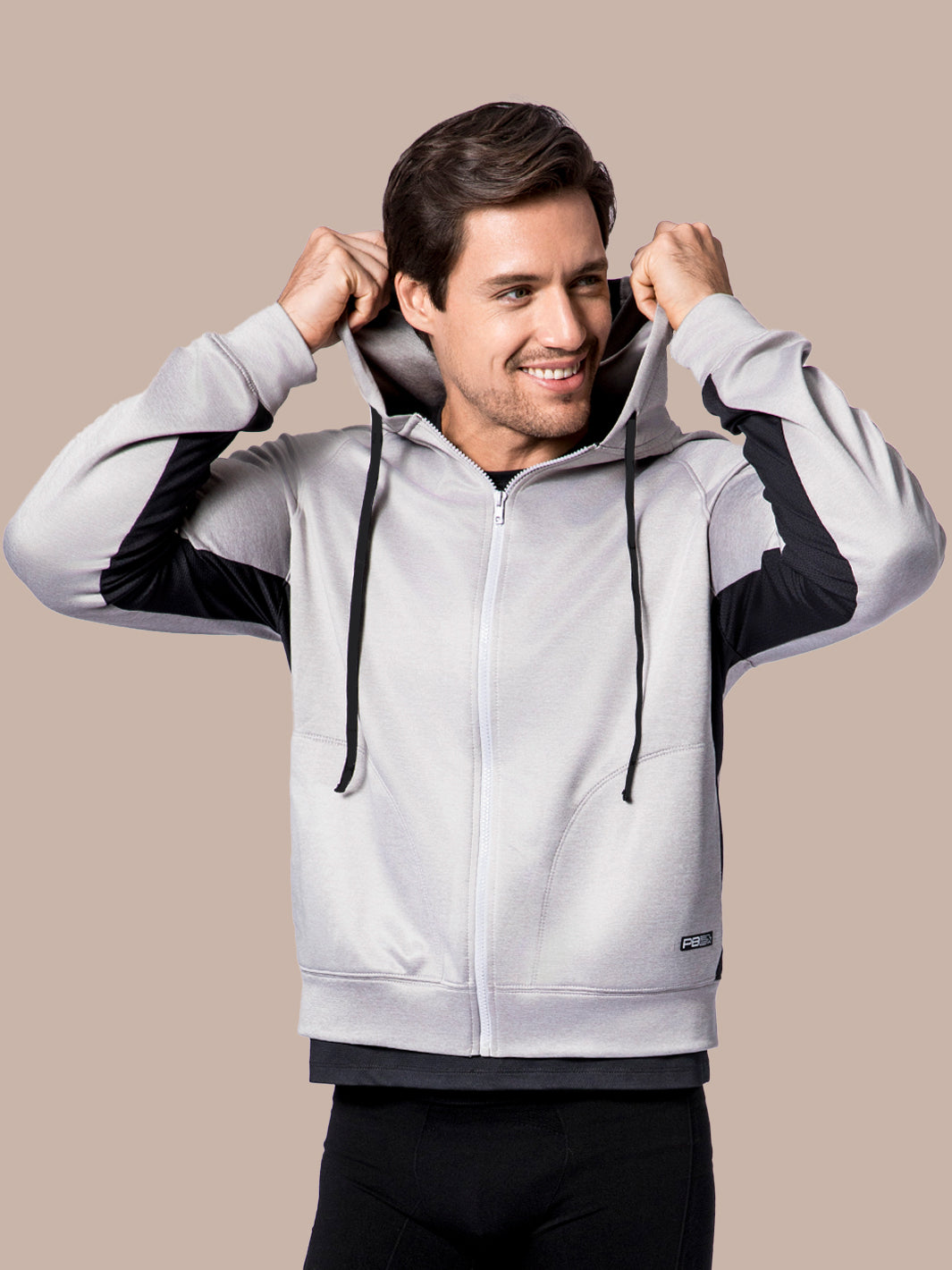 Male model pulling up the hood of a PB5 Star performance hoodie in grey heather with black accents and logo on a neutral background.