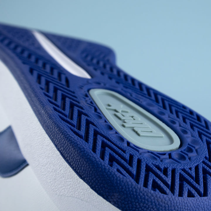 Close-up of a blue and white sneaker sole with a PB5 brand logo on a light blue background