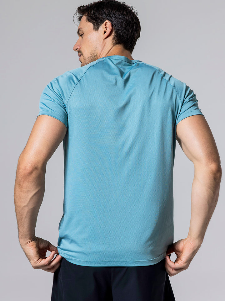 Man showing the back of the Arctic Core Performance Tee while wearing black Signature Court Shorts against a light gray background.
