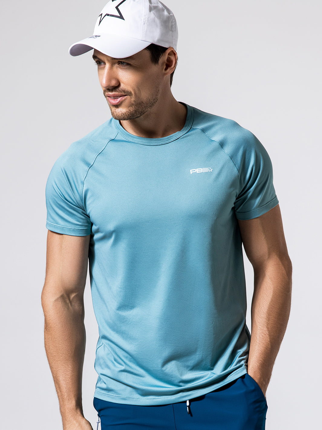 Man wearing Arctic Core Performance Tee, and white Stellar cap against a light gray background.