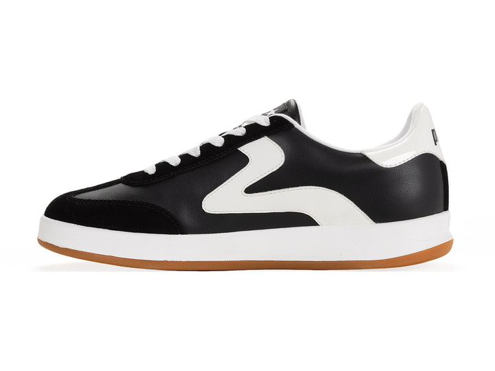 Medial side view of a black and white low-top sneaker with gum sole and metallic gold heel tab