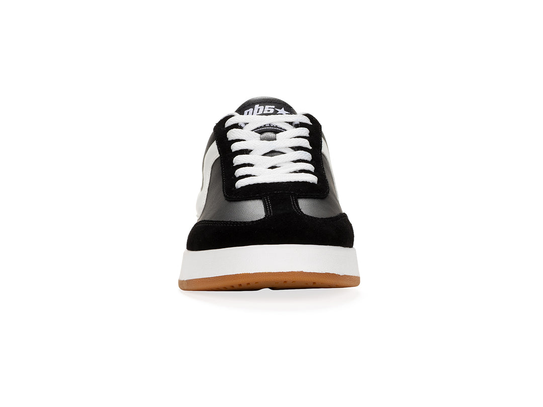 Front view of a black and white low-top sneaker with gum sole