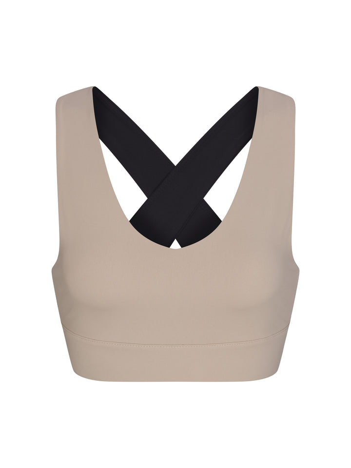 X-Over Back Sports Bra front view in soft clay and black.