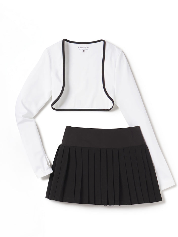 Women’s white cropped shrug with black trim and black pleated tennis skirt flat lay on white background