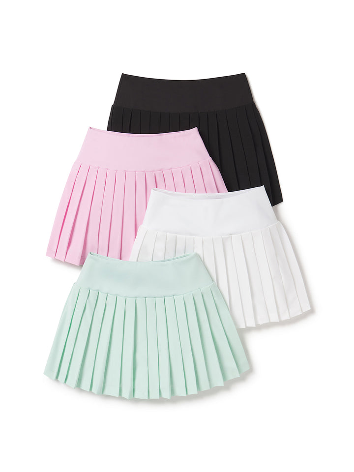 Group of women's side-split pleated athletic skirts in black, powder pink, white, and mint colors laid flat