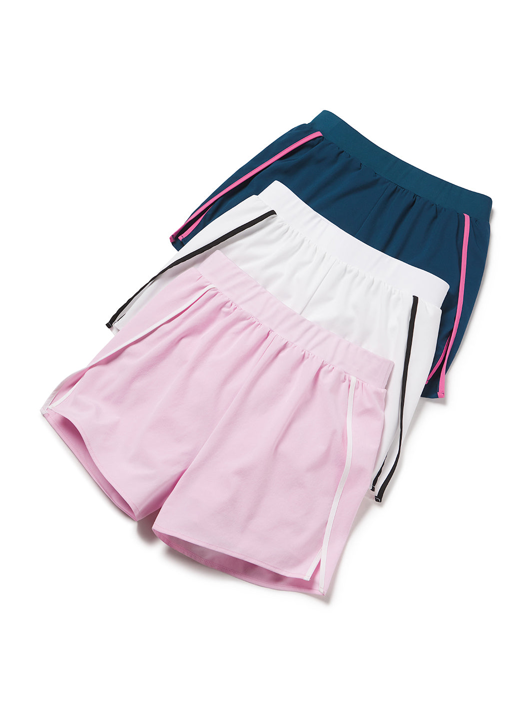 Group of women’s side-split athletic shorts in powder pink, white, and astral blue with contrast piping, flatlay display