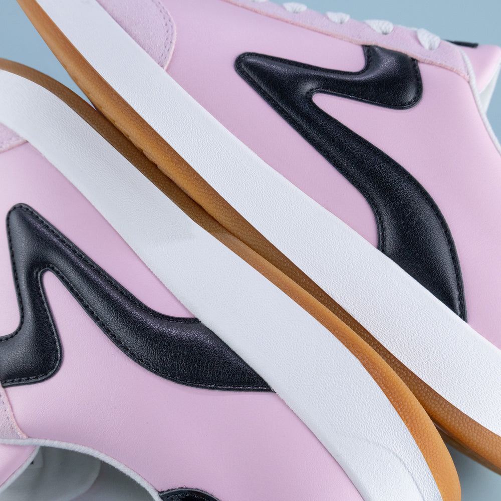 Close-up of pink sneakers with black starlet PB5star logo and white,  and tan soles.