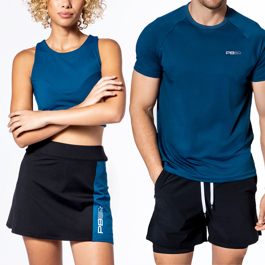 Male and female models in PB5star activewear, featuring an astral blue Racer Back Sports Bra and Mesh Panel Pickleball Skirt for her, and an astral blue Core Performance Tee and black Signature Court Shorts for him.